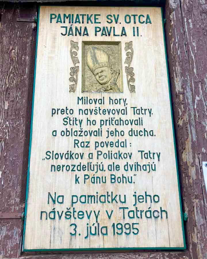 Pamätná tabuľa na stene kostola pripomínajúca návštevu pápeža Jána Pavla II. vo Vysokých Tatrách. Foto: autor.