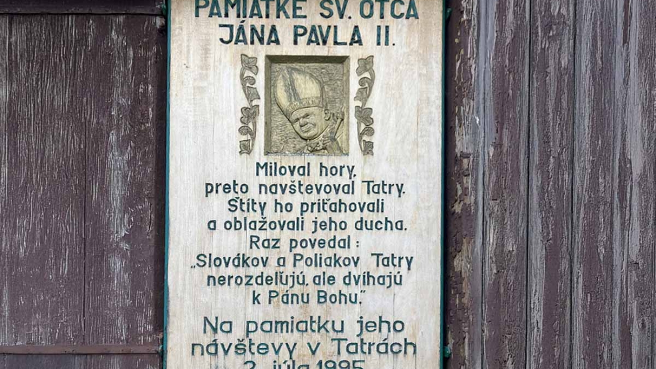 Pamätná tabuľa na stene kostola v Starom Smokovci, ktorá hovorí o návšteve Jána Pavla II. vo Vysokých Tatrách.