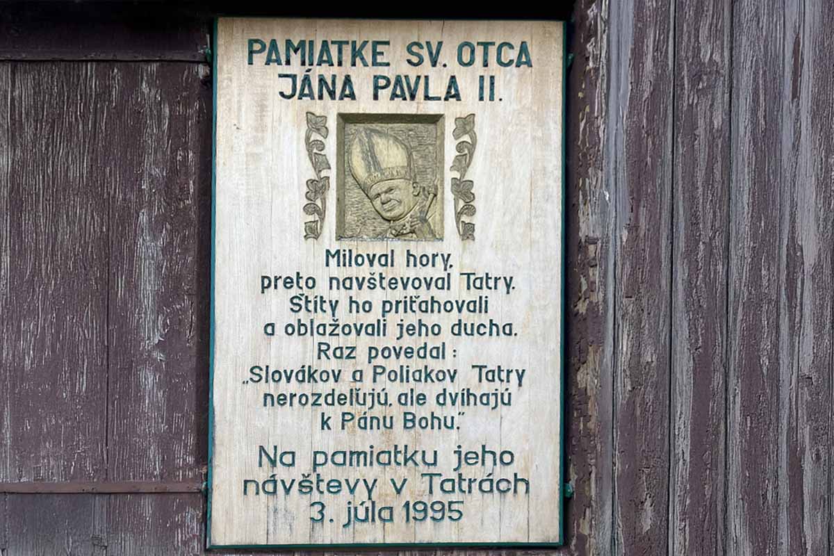 Pamätná tabuľa na stene kostola v Starom Smokovci, ktorá hovorí o návšteve Jána Pavla II. vo Vysokých Tatrách.
