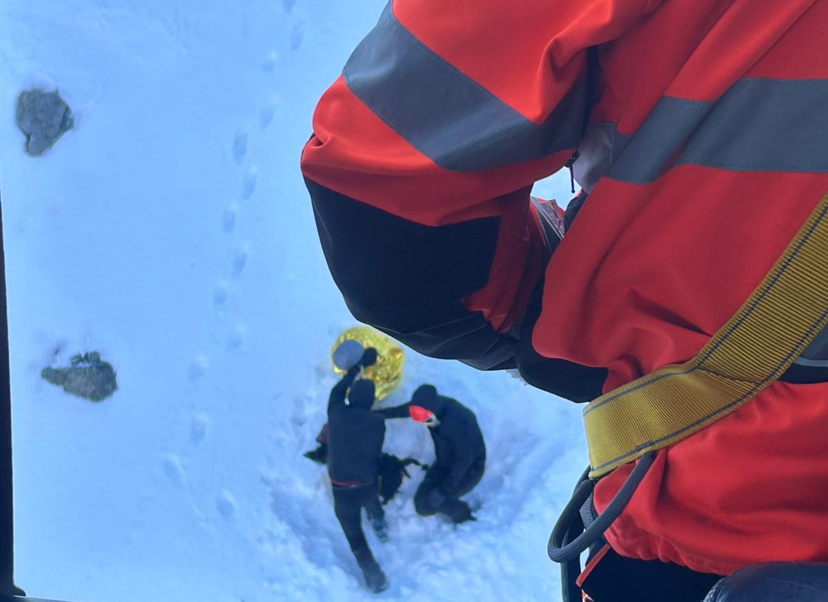 Záchranár ošetruje pacientku na svahu