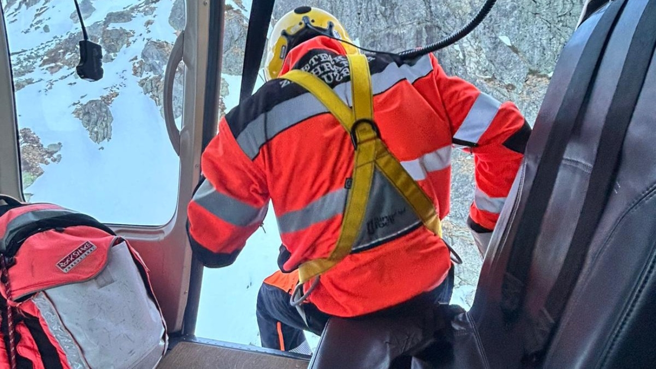 Záchranár smeruje z lietadla k zranenej žene na svahu