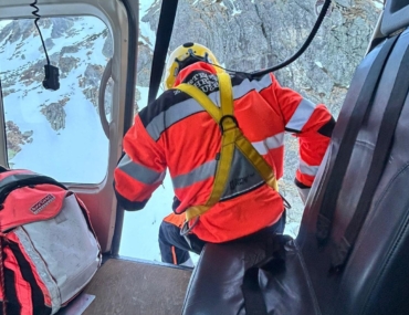 Záchranár smeruje z lietadla k zranenej žene na svahu