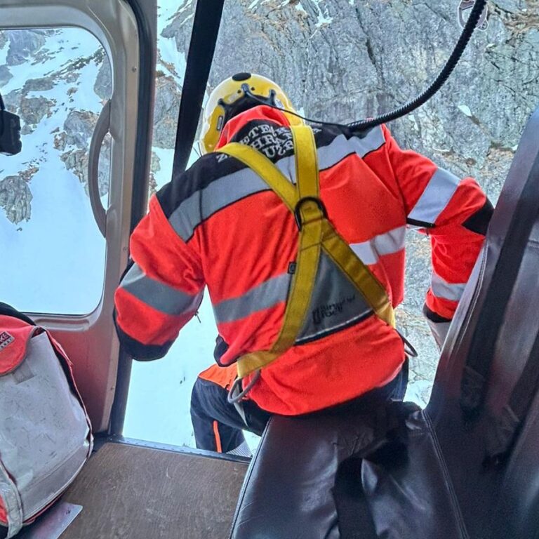 Záchranár smeruje z lietadla k zranenej žene na svahu