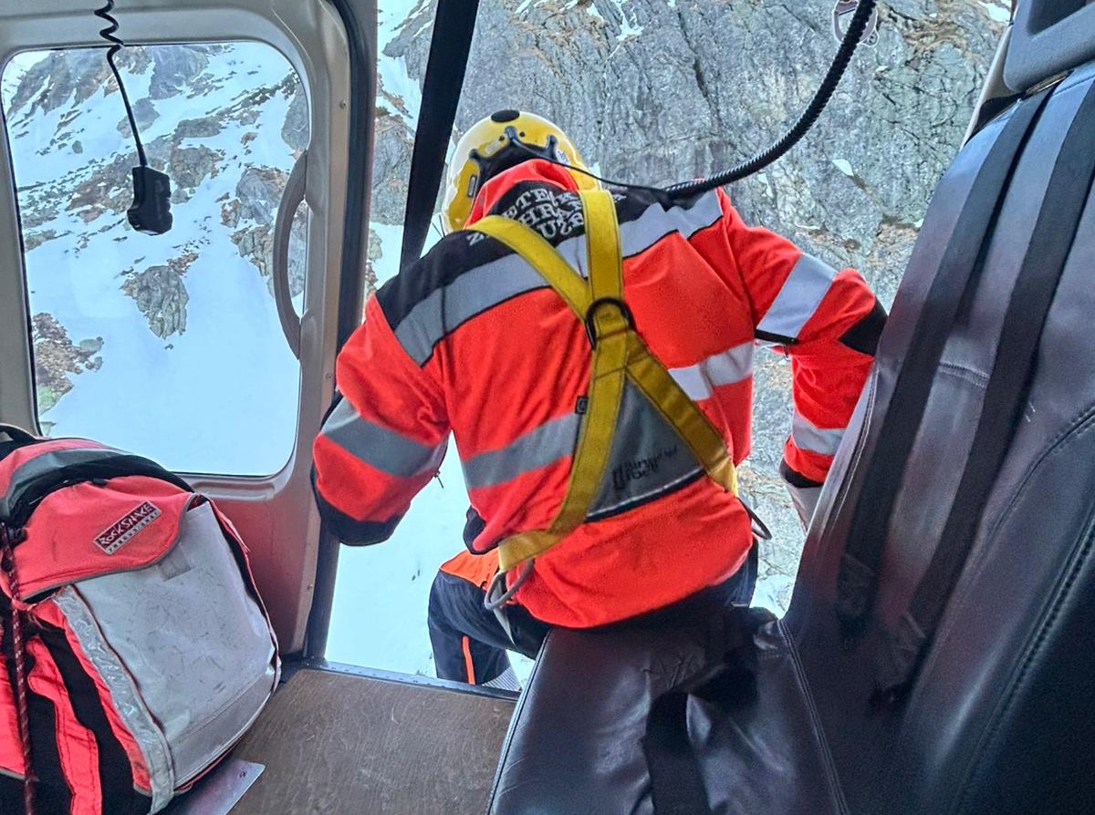 Záchranár smeruje z lietadla k zranenej žene na svahu